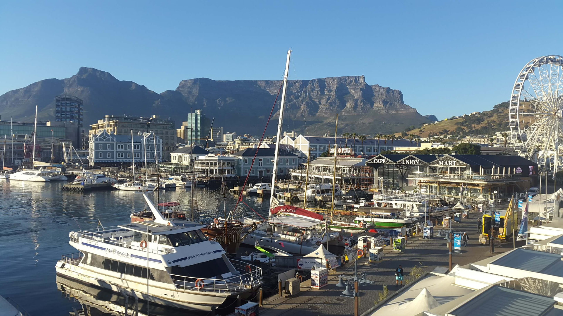 V&A Waterfront in Cape Town with boats in the harbour and Table Mountain rising in the background, the starting point for a Cape Point tour