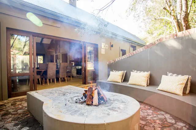 Outdoor braai area with fire at a Botlierskop Bush Villa