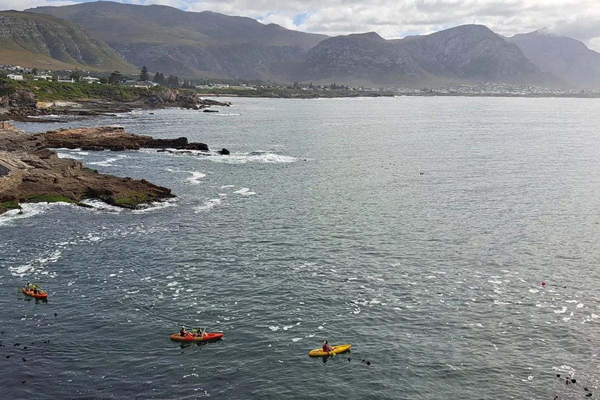 Kayaks beside the rocky Hermanus coastline on Walker Bay