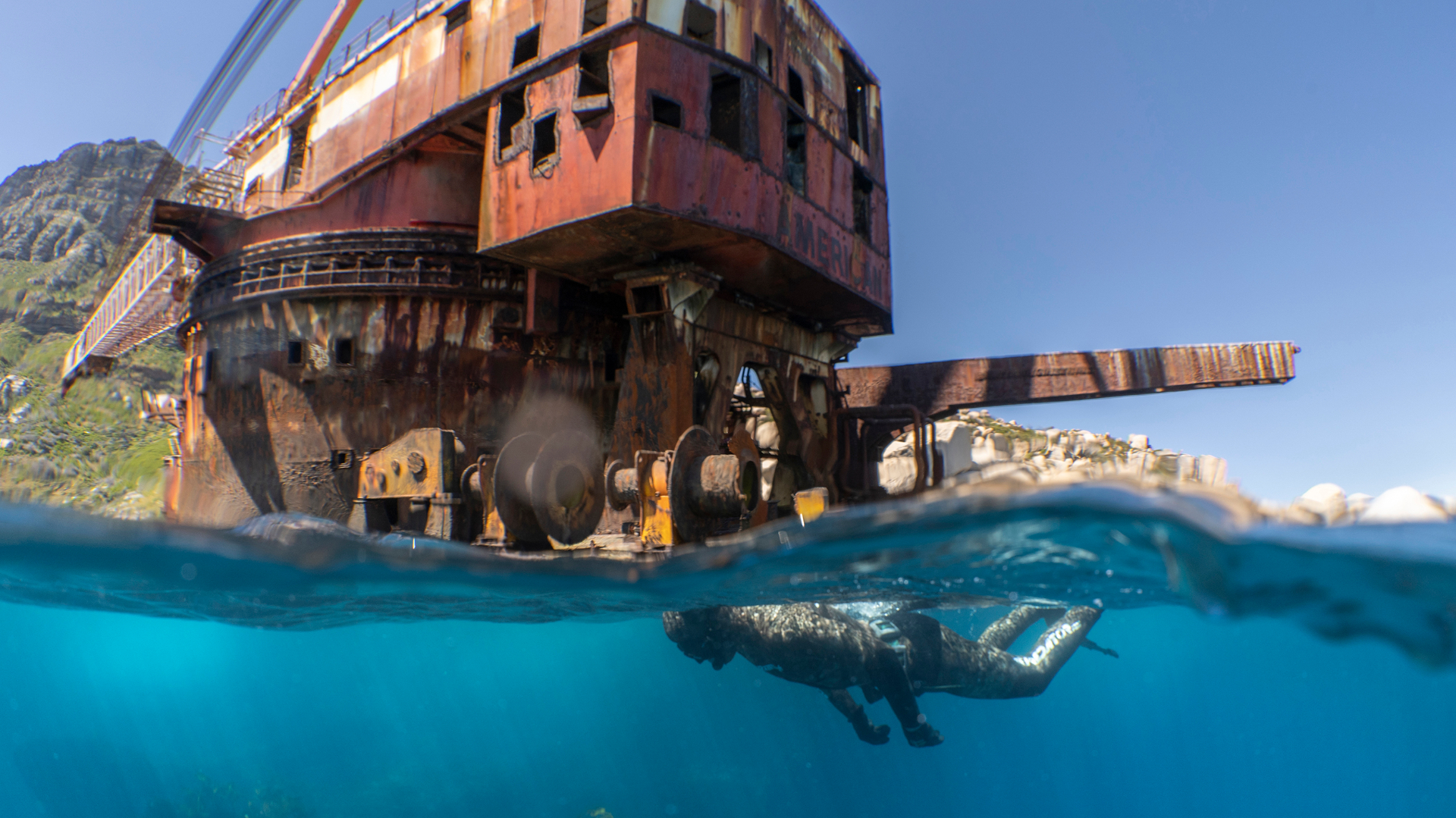 Split shot of a snorkeler exploring a shipwreck along Cape Town's remote Atlantic coastline